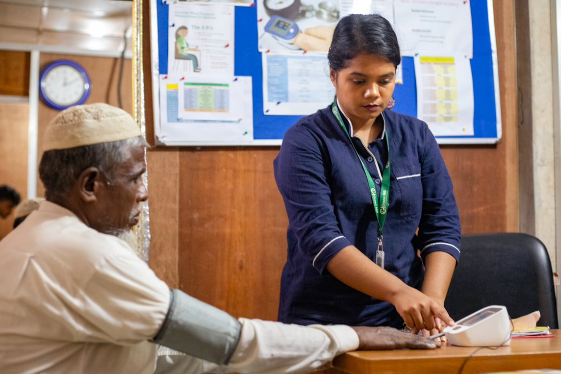 Triage worker Mishel (right) measures the blood pressure or a patient at the CPI-supported health post in Kutupalong Refugee Camp, Bangladesh.
